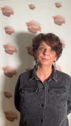 Patricia, ancienne élève d’ATMA, devant le mur aux couleurs de l’école